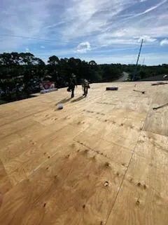 A couple of men standing on top of a roof.